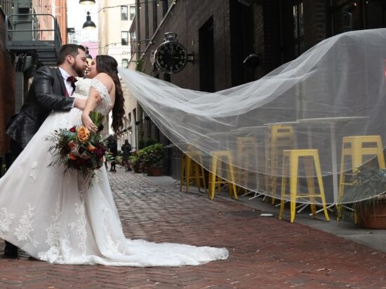 new husband and wife on a brick street in Michigan with a long veil
