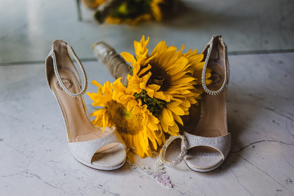 bouquet of sunflowers next to a pair of wedding heels for a rustic fall wedding