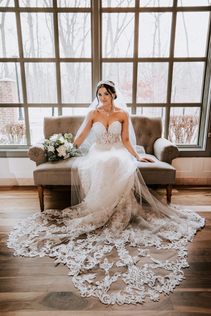 a bride sitting on a couch with a bouquet of flowers at the 2Gather Venue in Michigan