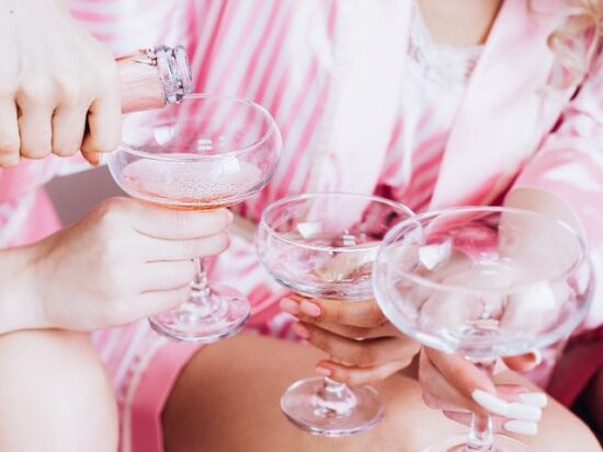 women pouring pink champagne for a Barbie themed bachelorette party