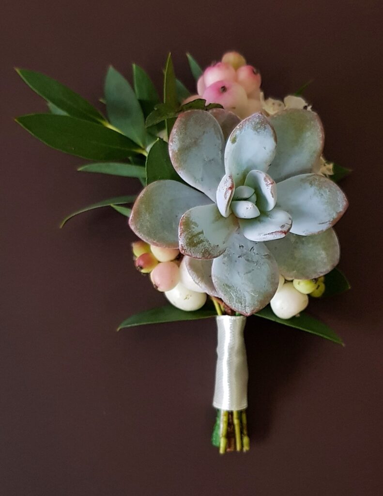 a stylish succulent boutonniere for a groom