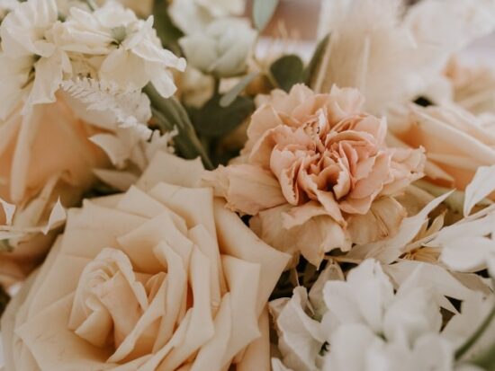 a bouquet of pink and white flowers with greenery