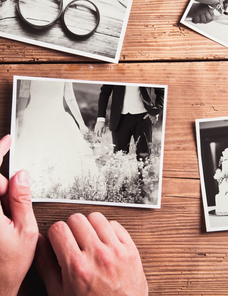 four black-and-white wedding photographs on a wooden table