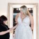 woman in black helping a bride with wedding dress alterations
