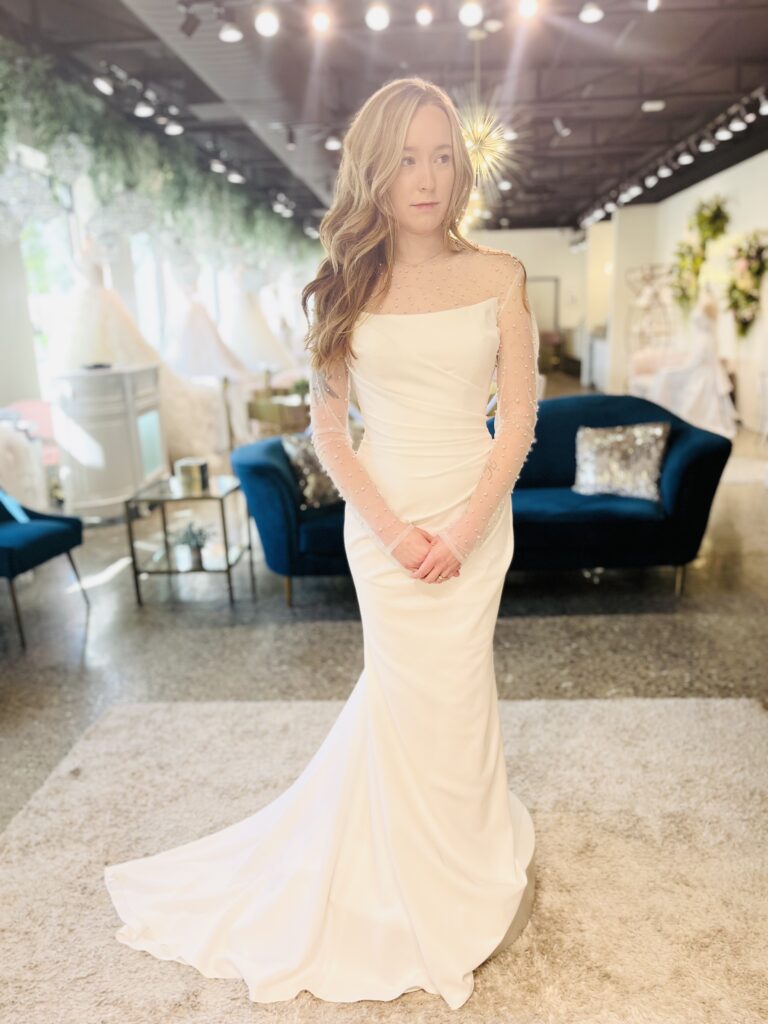 Wyatt is a fit and flare gown with rouching and a unique neckline paired with a pearl scatter bolero.