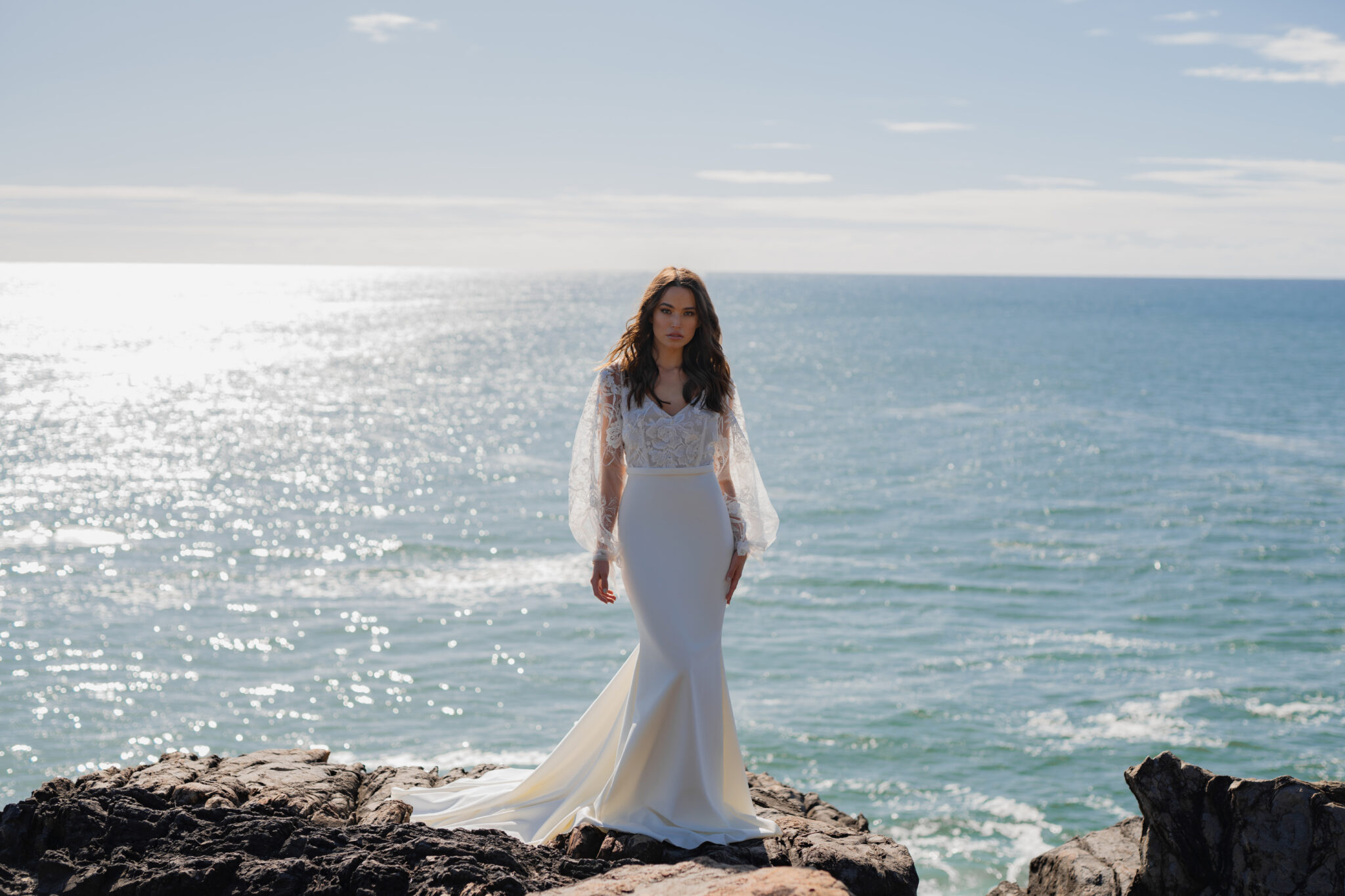 woman standing on cliff overlooking ocean and wearing saige couture wedding dress from Anna Campbell