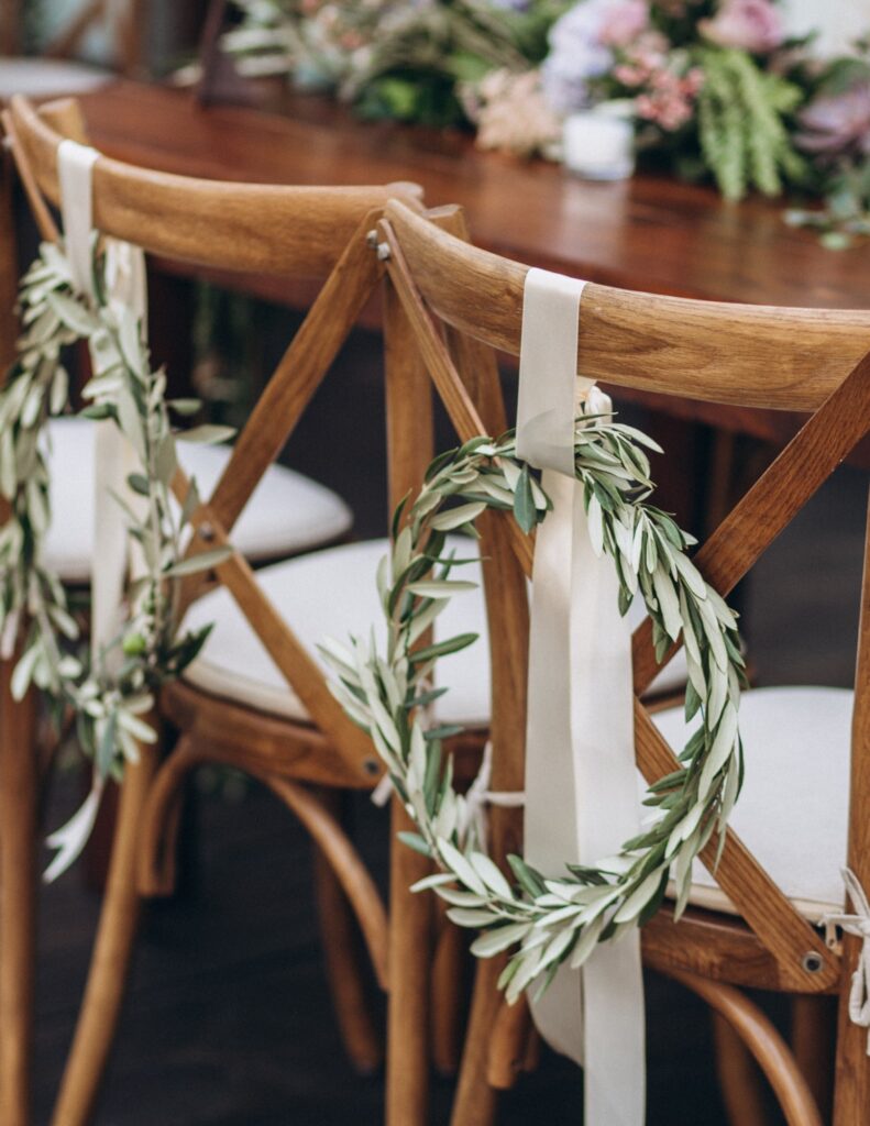 a wooden table and chairs decorated with plants