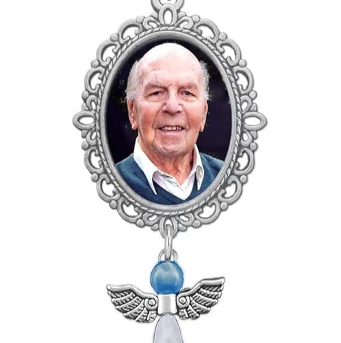 Silver bouquet charm with a picture of a friendly looking, elderly man in the middle.