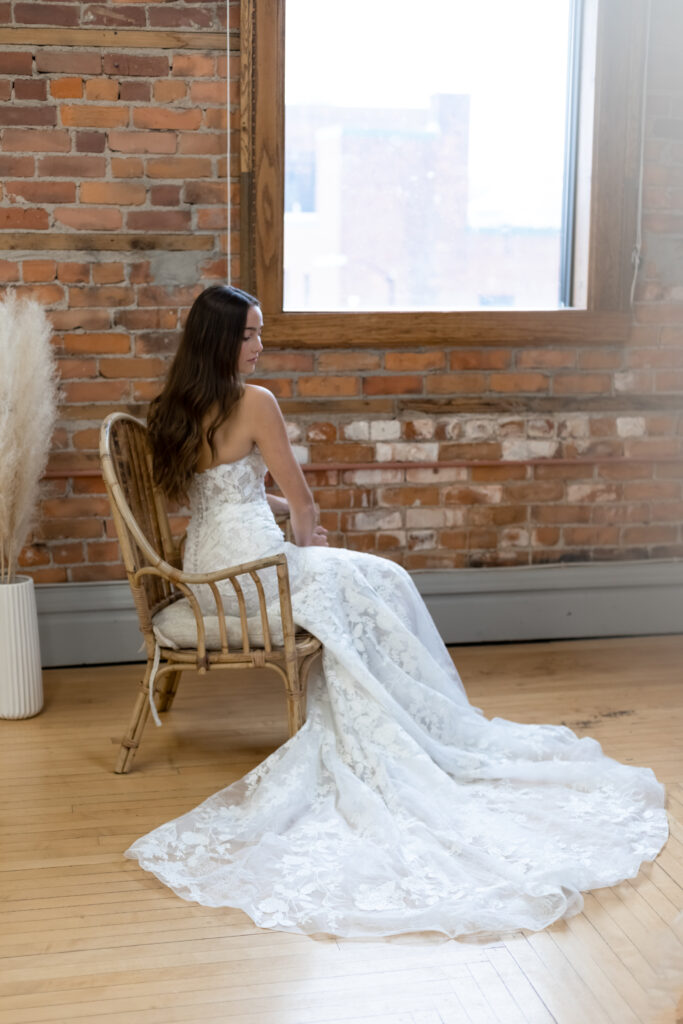 The Damen is a fitted gown with an intricate, double-layer lace pattern. The dress has a sweetheart neckline and a modern, corseted bodice.