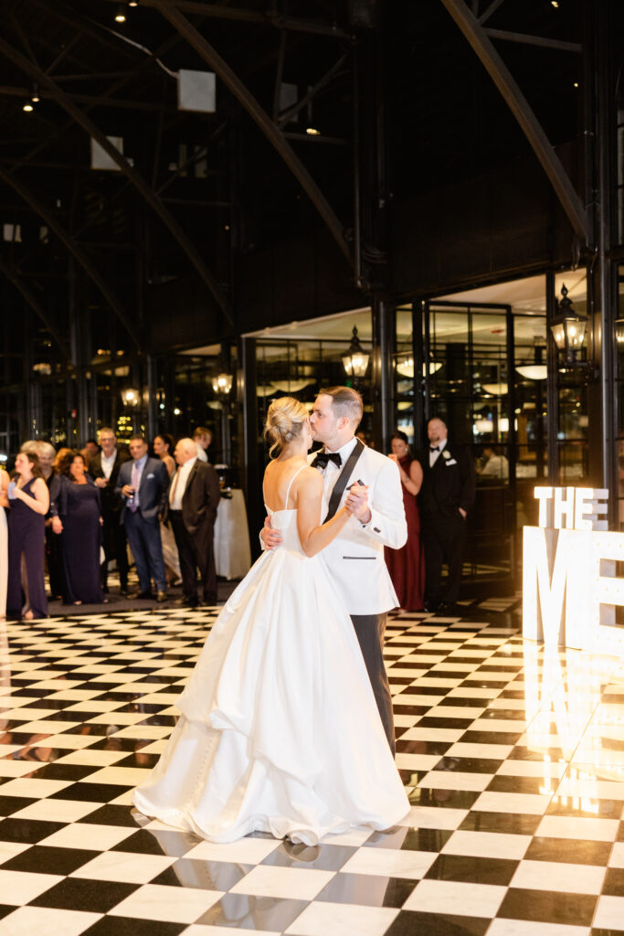 bride and groom dancing on a checkerboard floor at their wedding reception