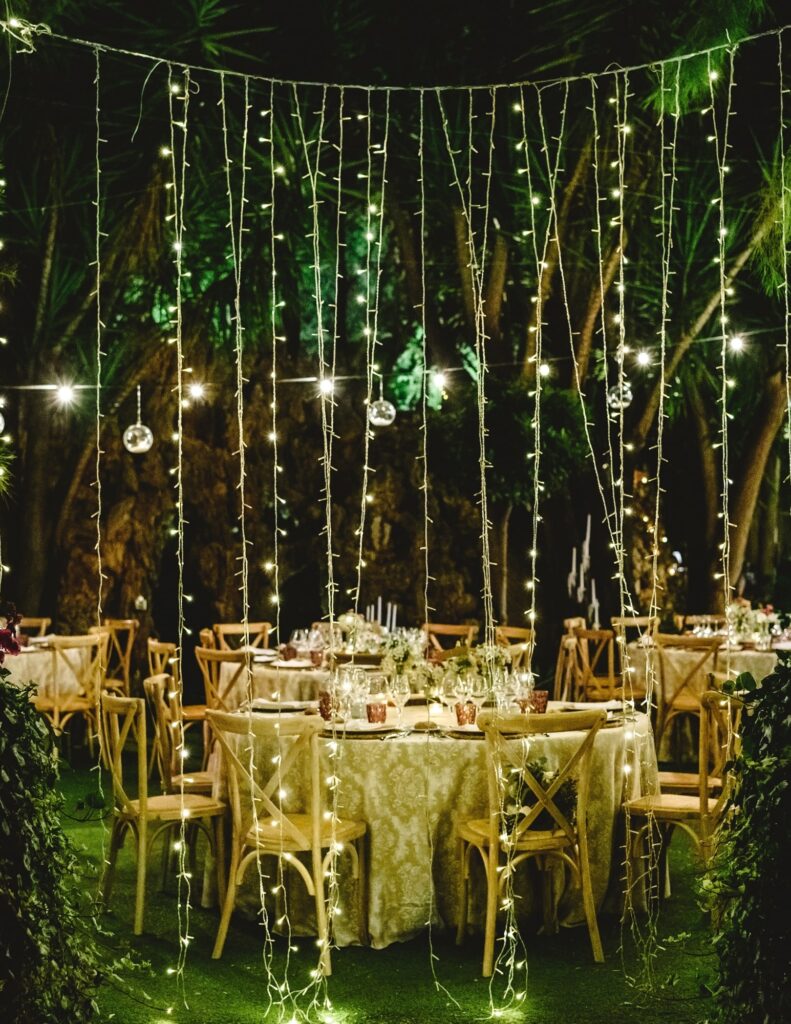 curtain of hanging lights in front of dining tables for a celestial wedding