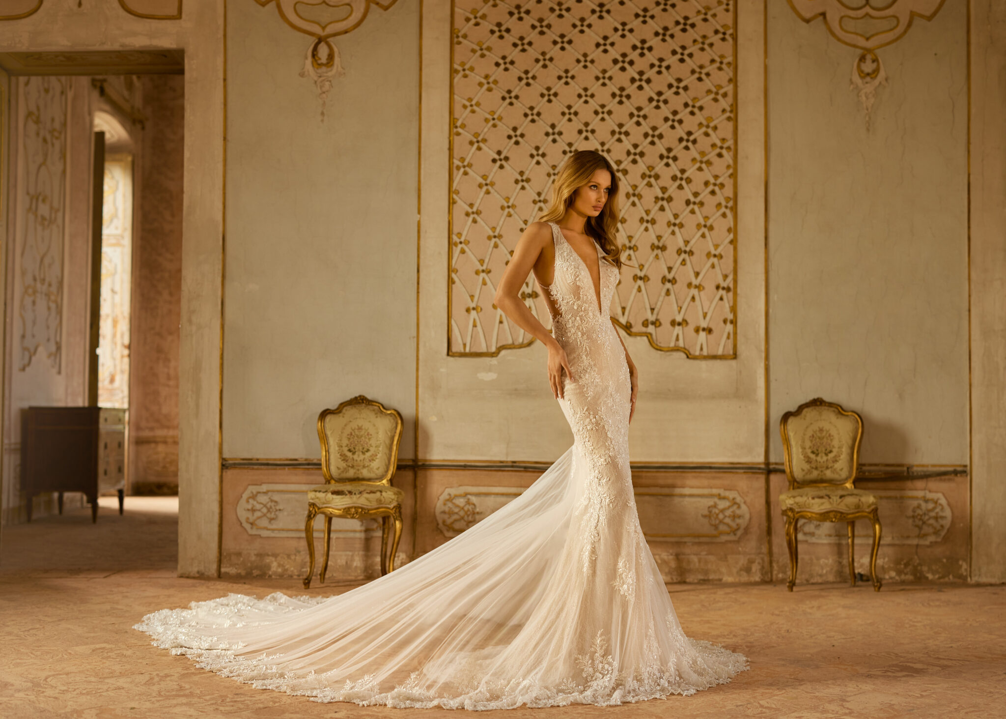 woman standing in classical style room and wearing couture wedding dress form Madam Burcu