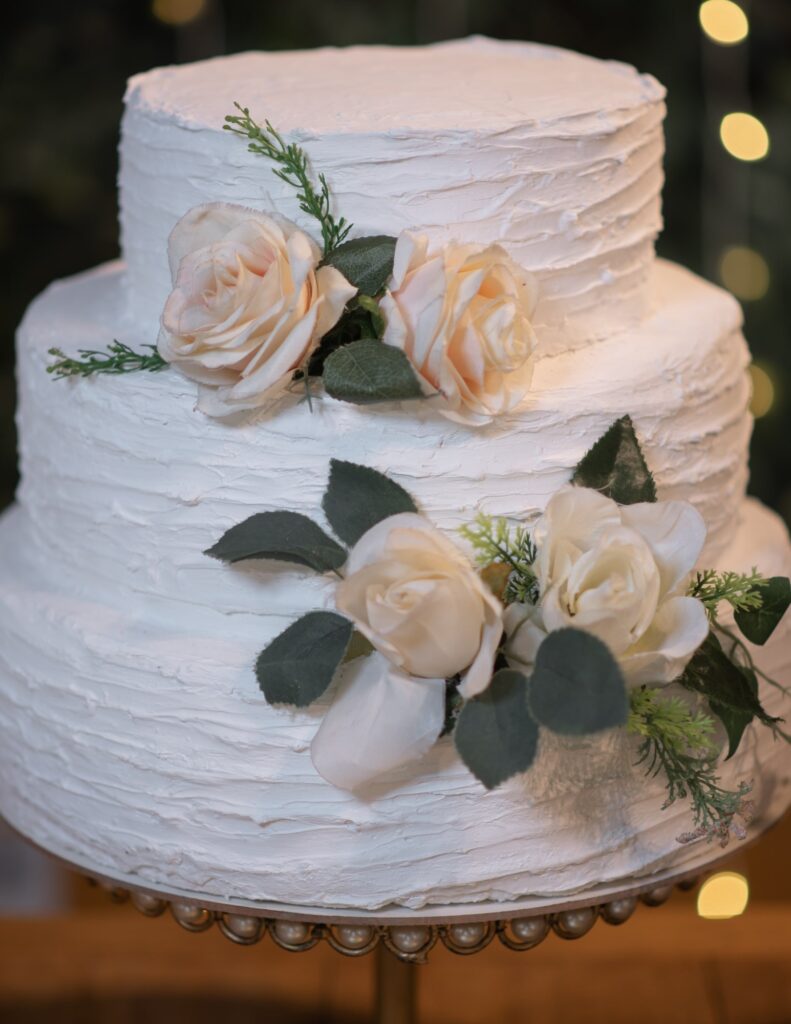 minimalist wedding cake with white frosting and roses