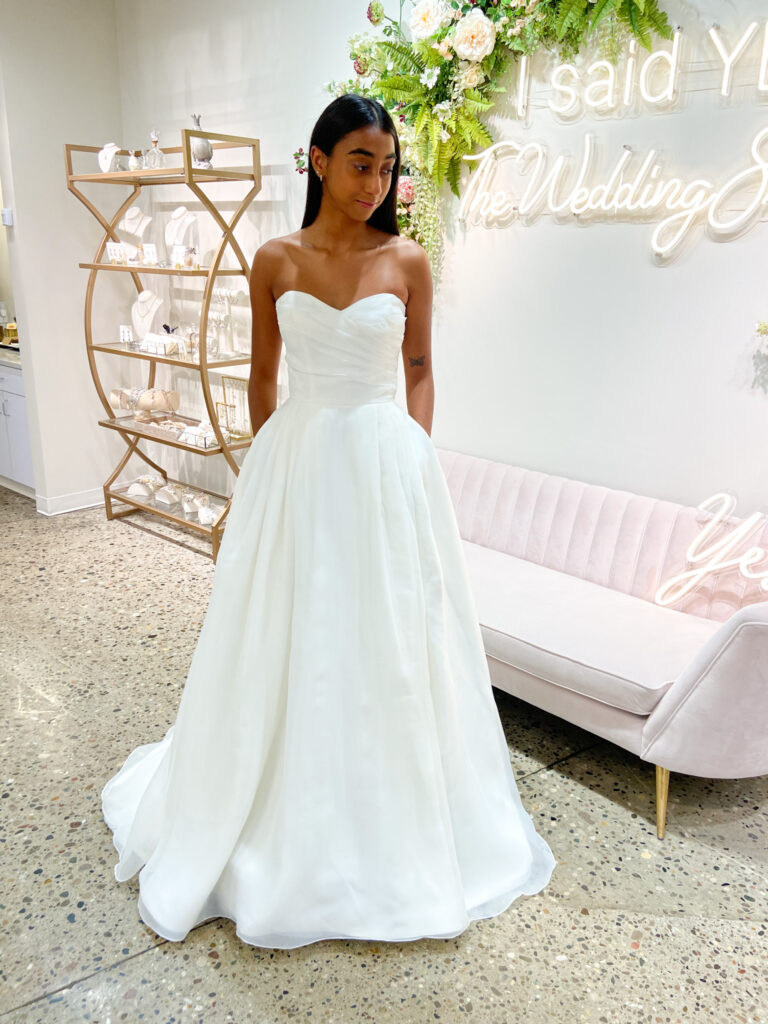Olivia is a candlelight-colored wedding dress with a rouched bodice and pockets