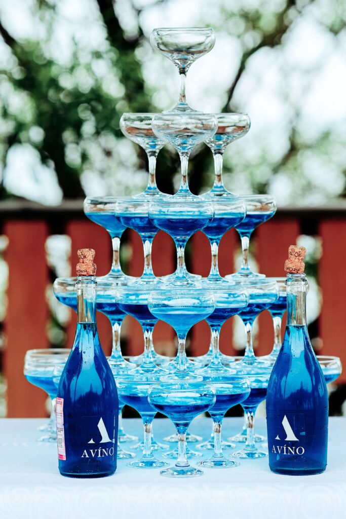 a tower of glasses with blue Avino in them