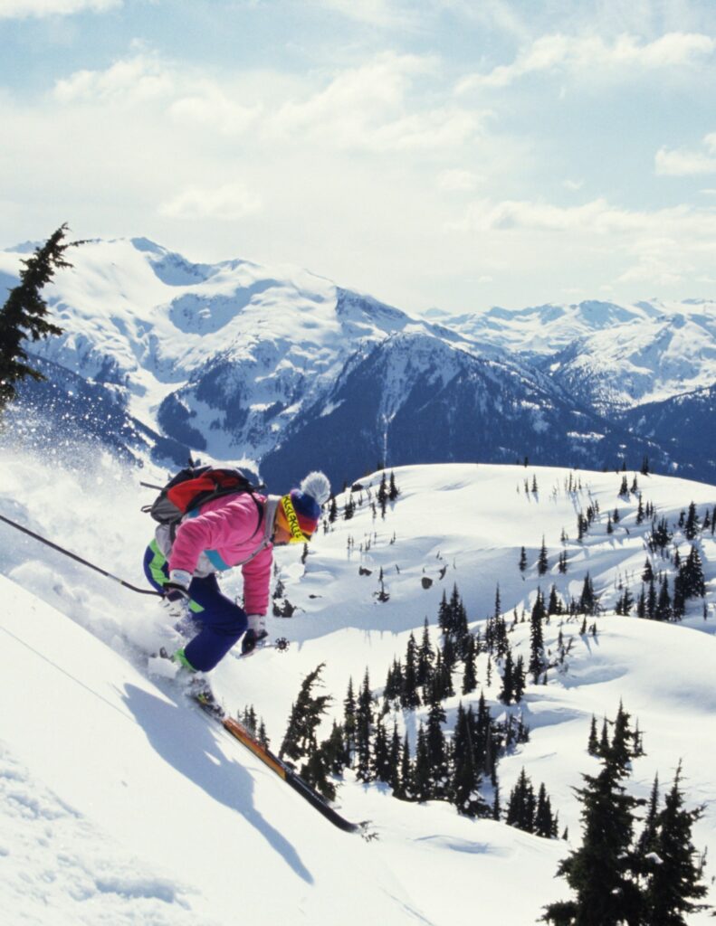 a man skiing in British Columbia down a snow-covered mountain