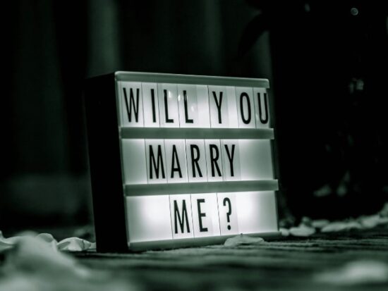a white sign lit from inside with the words "Will You Marry Me" written on it