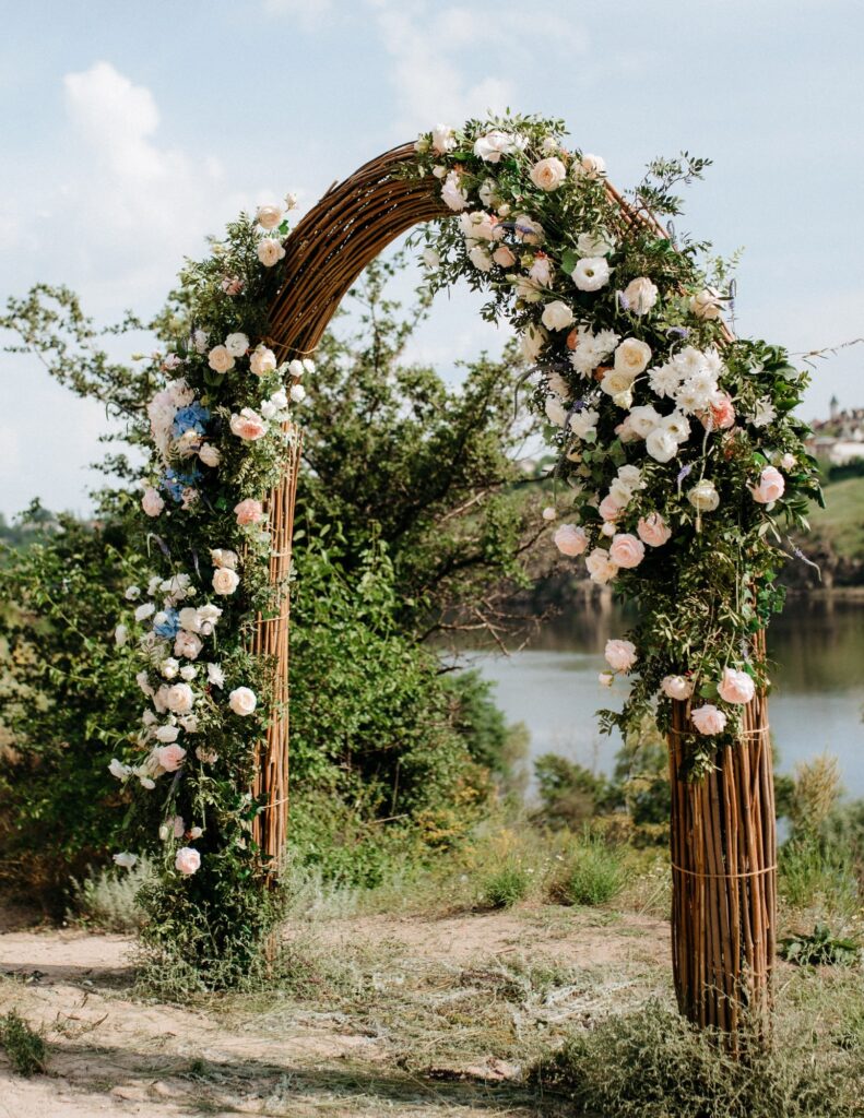 a natural arch as an altar for an outdoor wedding adorned with flowers
