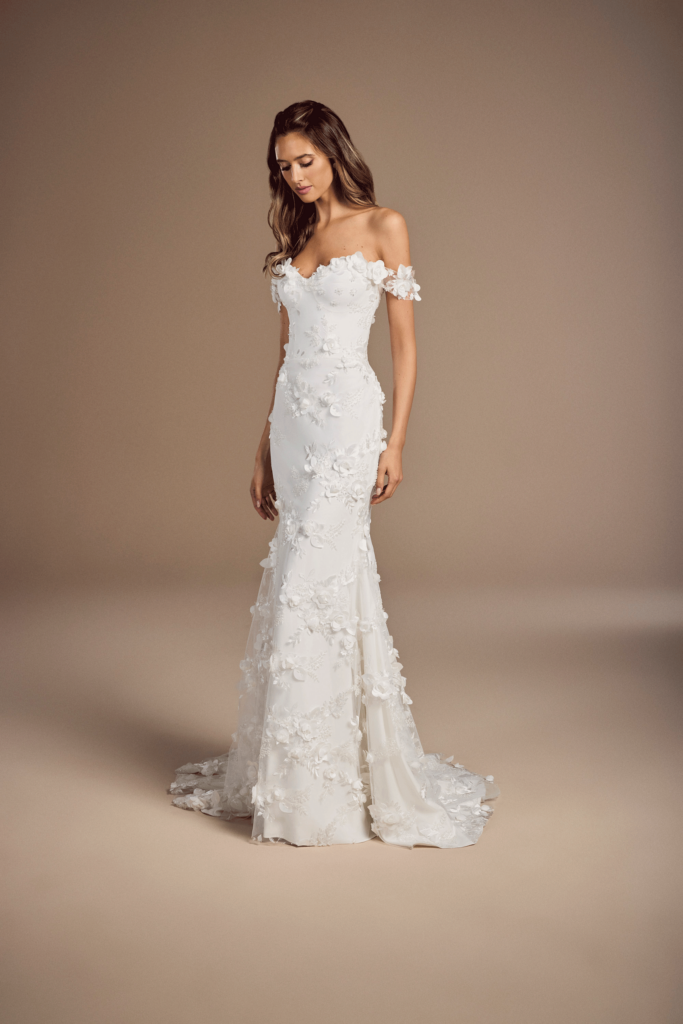 Debussy by Suzanne Neveille is a gown with textured lace applique and off-the-shoulder sleeves
