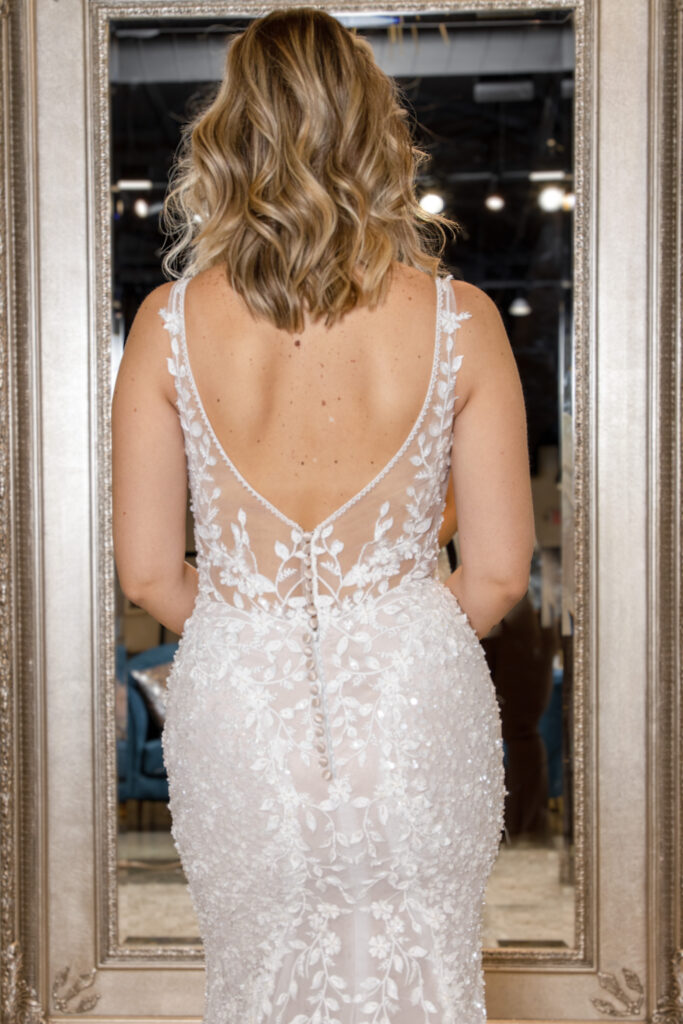 Octavia is a gown covered in a leafy lace pattern and adorned with full beading. This is the back of the dress.