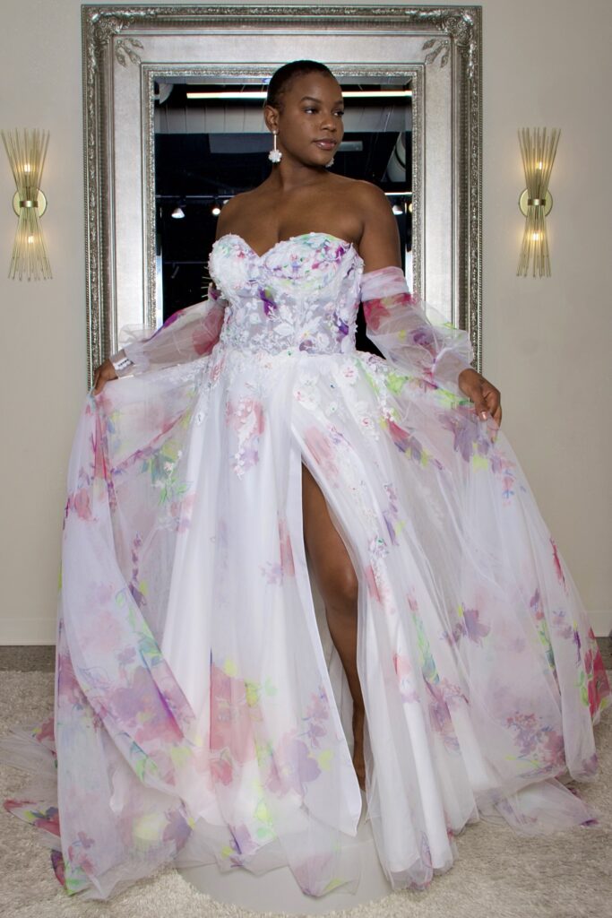 Presley is a sweet heart gown with 3D applique and removable off the shoulder sleeves and a slit.