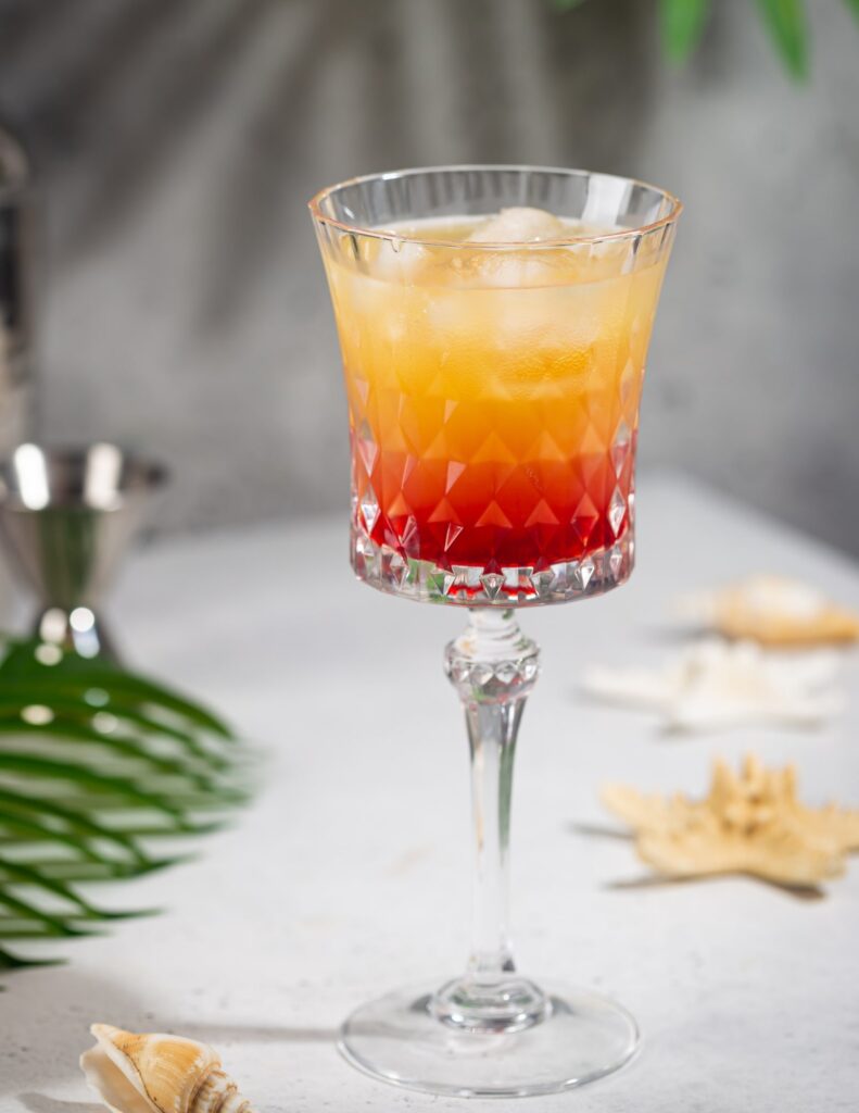 a colorful orange and red tequila sunrise cocktail in a glass