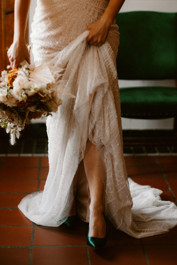 a bride holding a bouquet on her wedding morning with her leg out in front of her