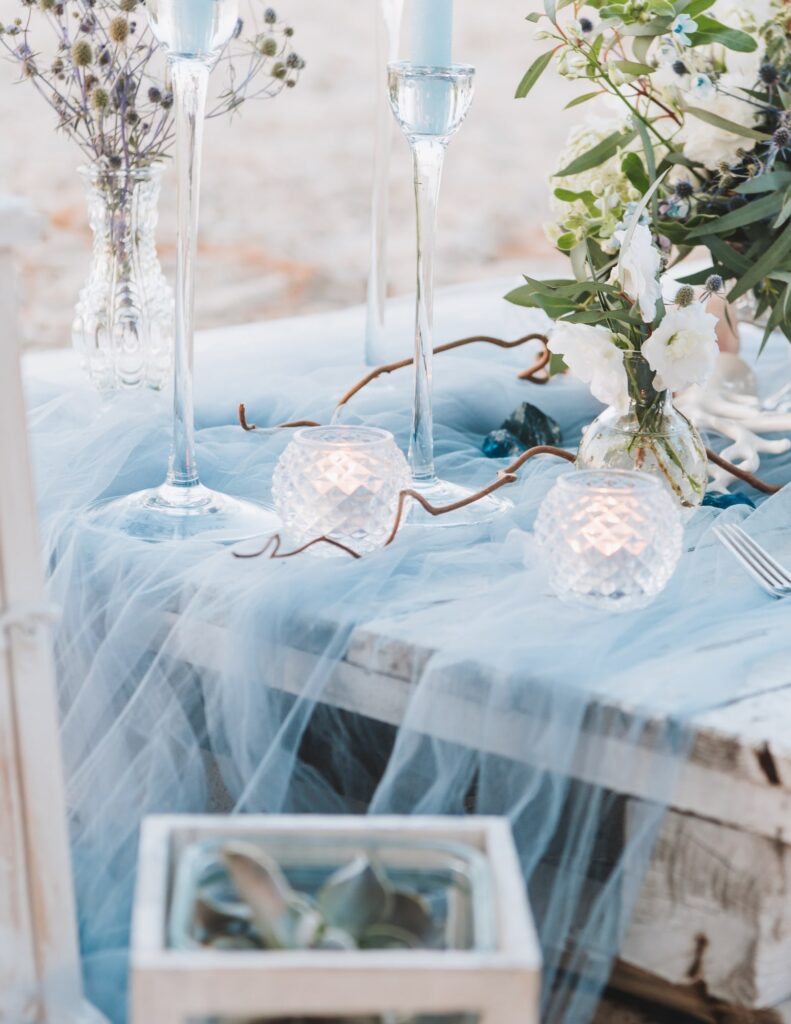 an elegant table set up for a wedding in a dusty blue color