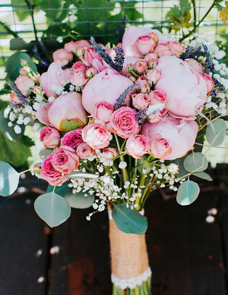 an overflowing bouquet filled with pink and purple flowers like peonies for a spring wedding