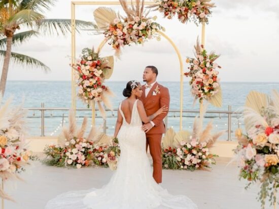 wedding overlooking the ocean in a tropical setting surrounded by tons of flowers