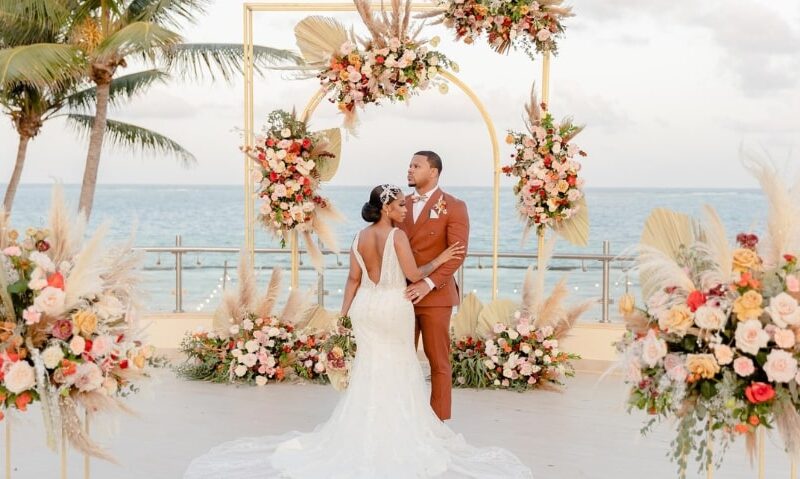 wedding overlooking the ocean in a tropical setting surrounded by tons of flowers