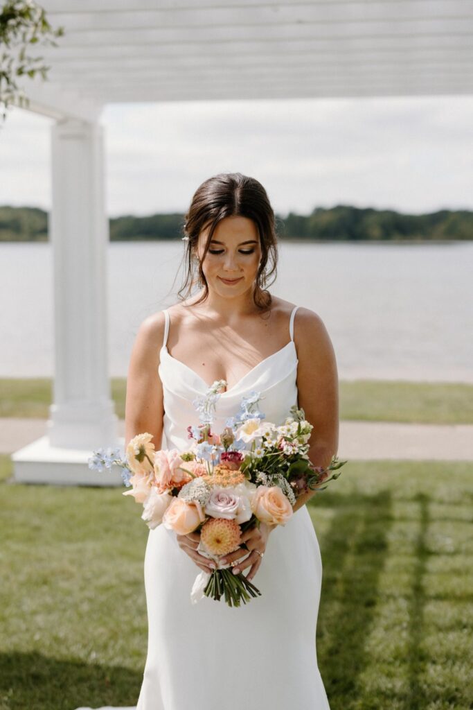 bride holding light colored pastel flower bouquet