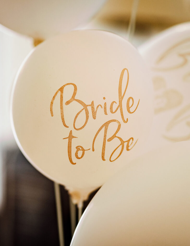 white balloons with "bride to be" written on them in gold