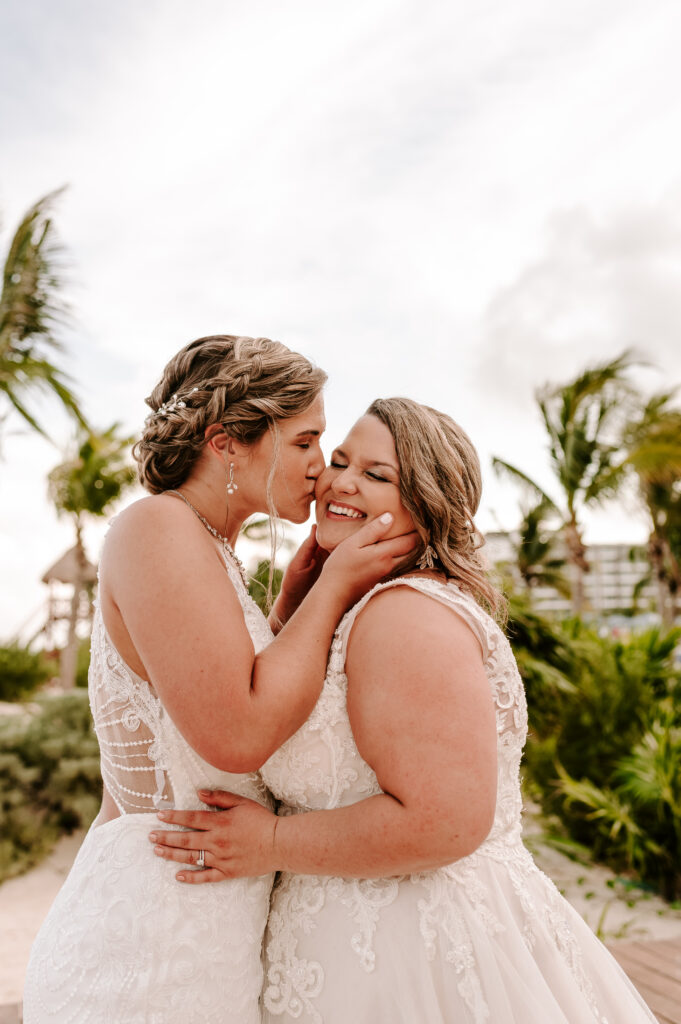 newly married brides kissing in a tropical location