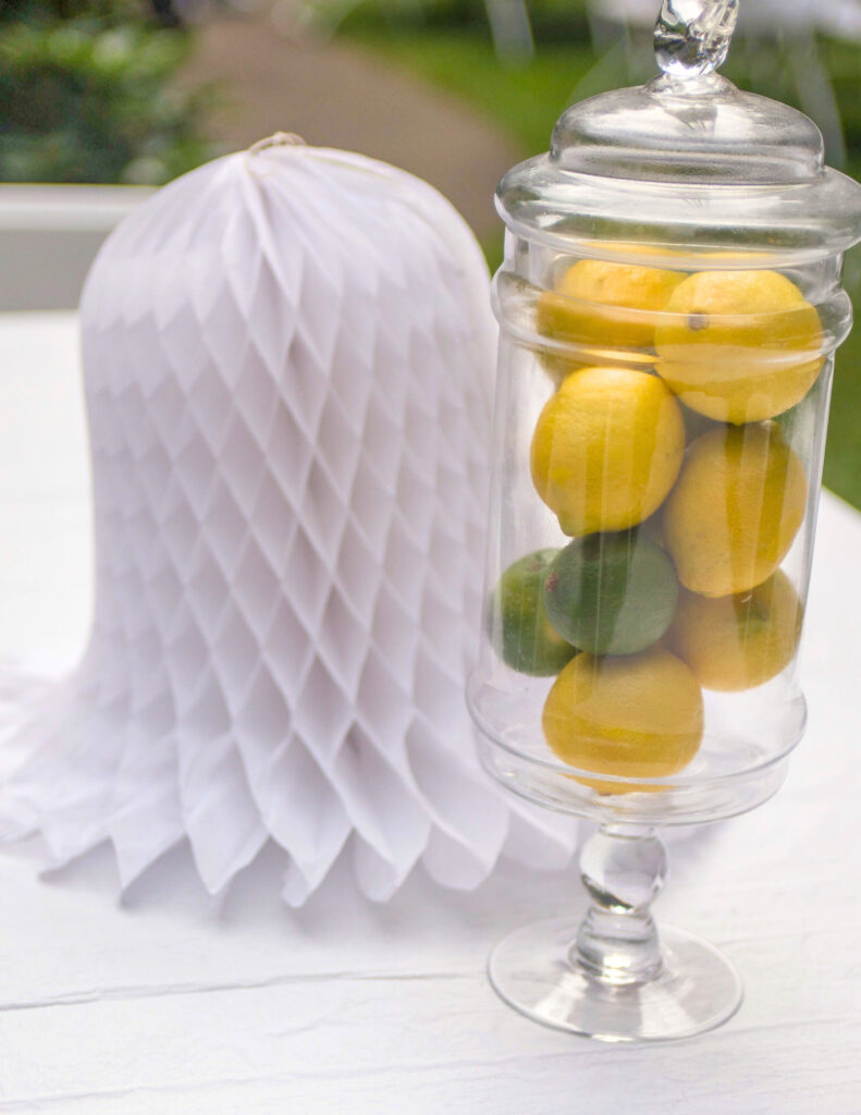 a table centerpiece of a glass jar of lemons and limes