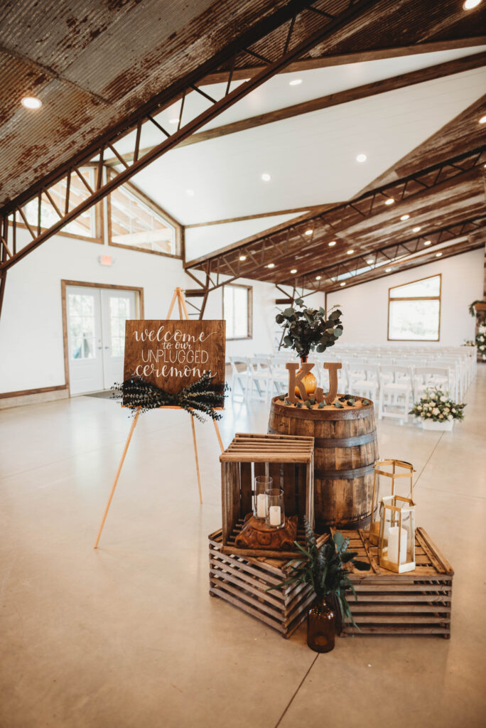 barrels, crates, and a wooden sign as rustic wedding aisle décor