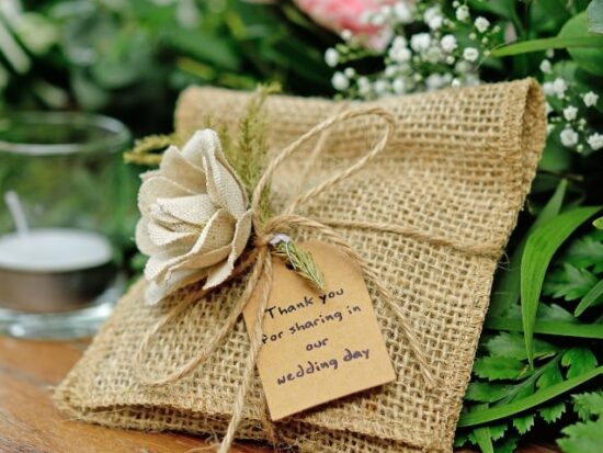 small burlap wedding favor with a fabric rose tied to it for a summer wedding