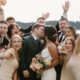 the bridal party celebrating around the bride and groom as they kiss