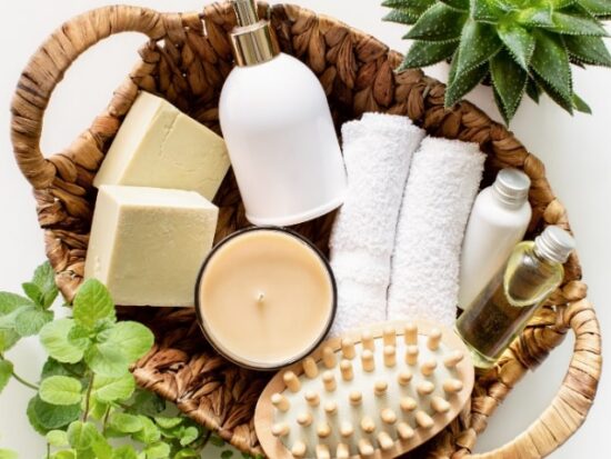 spa day basket full of gift ideas for the bride-to-be, including soap, washcloths, a candle, and a brush