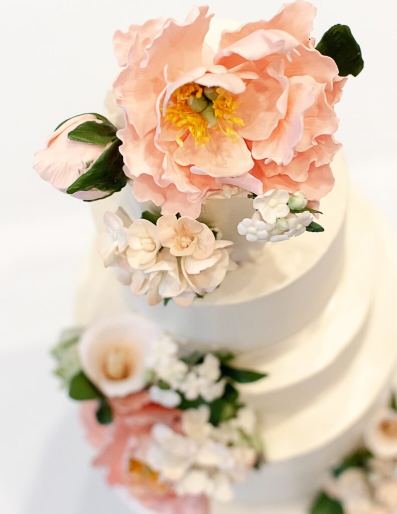a beautiful tiered wedding cake decorated with edible flowers for a fantasy wedding