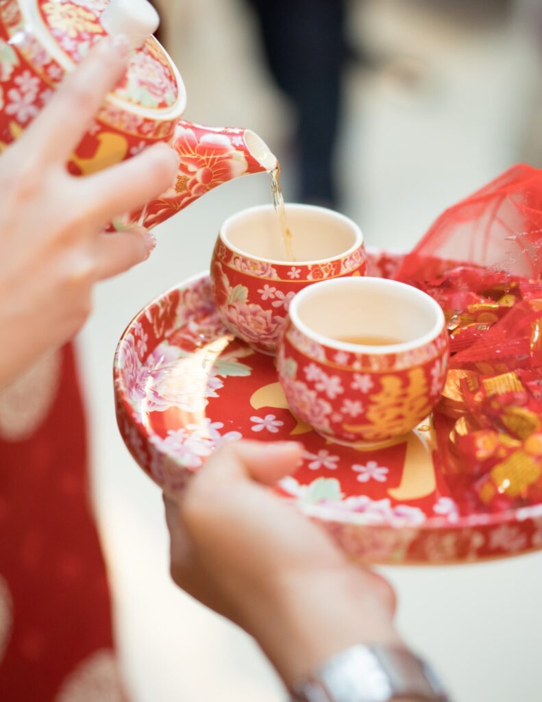 woman pouring tea into an intricately decorated cup as a wedding tradition