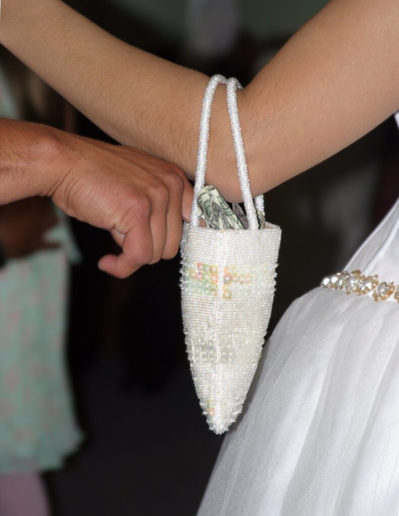 a man putting money into a bag as a part of a traditional wedding money dance