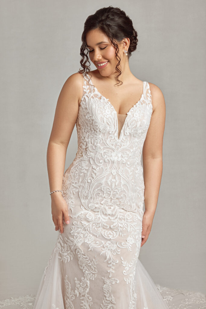 woman smiling in a close-fitting vintage gown at a Michigan wedding store