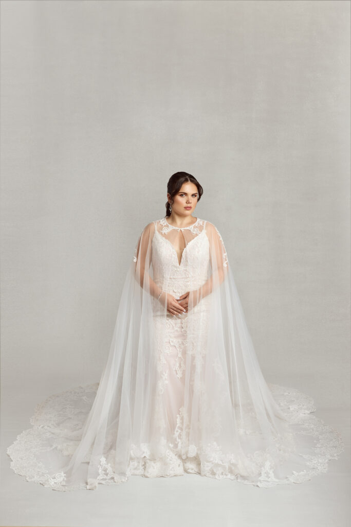 Bride wearing the "Dramatic Cape," a floor-length lace cape that acts as an alternative to a traditional bridal veil