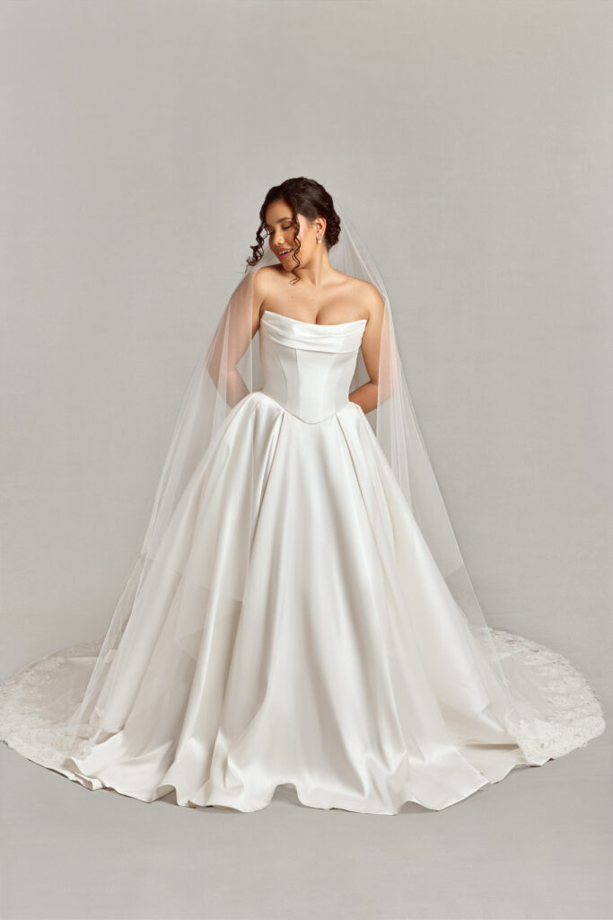 Woman wearing a simple, elegant wedding ballgown with a long veil