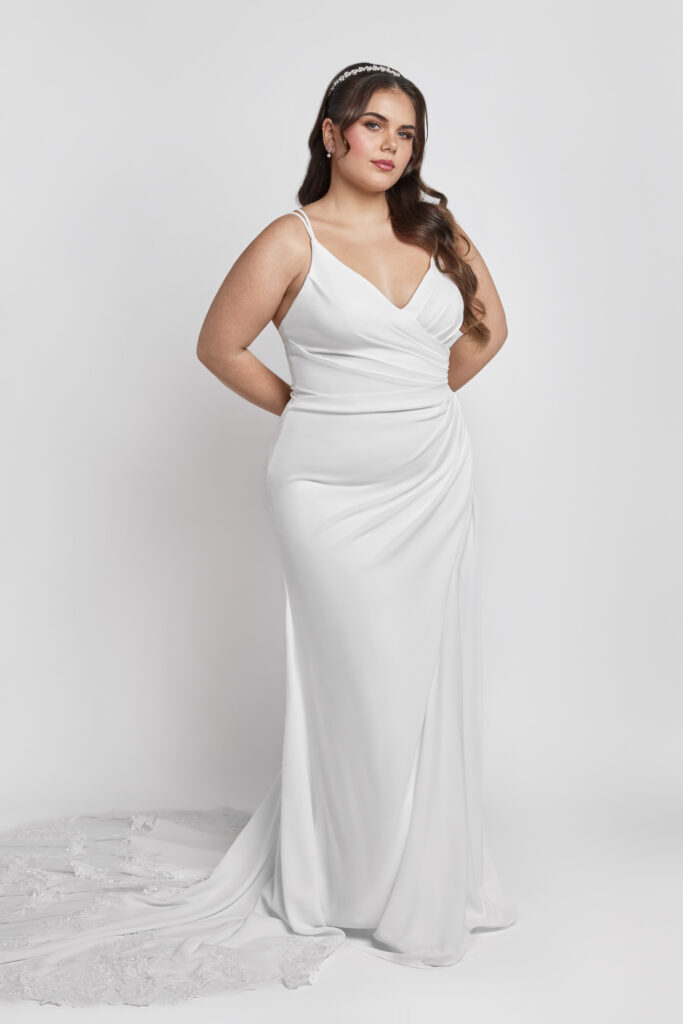 A clean, classic plus-size wedding gown with a modern ruched bodice and a long lace train