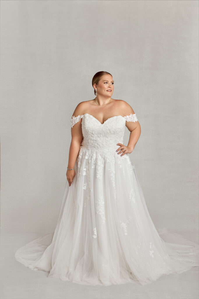 Woman wearing a strapless off-shoulder a-line dress with a full lace bodice.