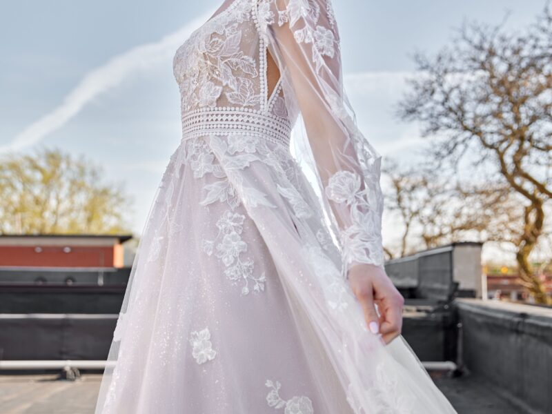 Stunning bride to be modeling one of The Wedding Shoppe's western wedding dresses. The lace long sleeve wedding dress has floral detailing throughout.