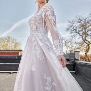 Stunning bride to be modeling one of The Wedding Shoppe's western wedding dresses. The lace long sleeve wedding dress has floral detailing throughout.