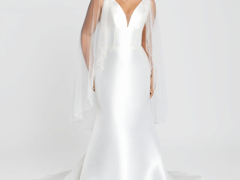 Bride to be wearing a classic wedding dress with a fit and flare style and a deep v cut neckline.